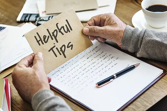 A person holding a card that says 'helpful tips'