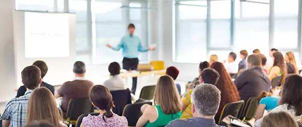 A person speaking to a group of seated people