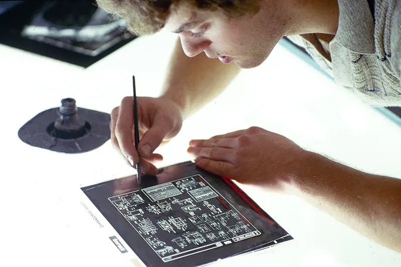 An old photo of a Thomas employee filling in pinholes