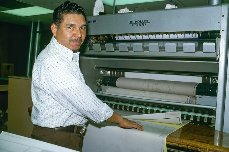 An old photo of a Thomas employee operating a diazo machine