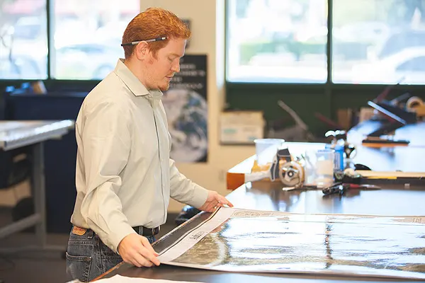 A TPW employee examining a color print